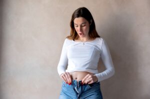 Woman unable to button jeans due to chronic bloating and abdominal distension