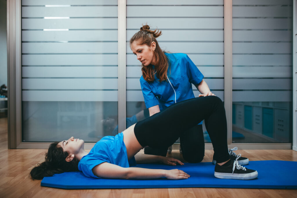 Physical therapist evaluating muscle coordination and pelvic stability during movement